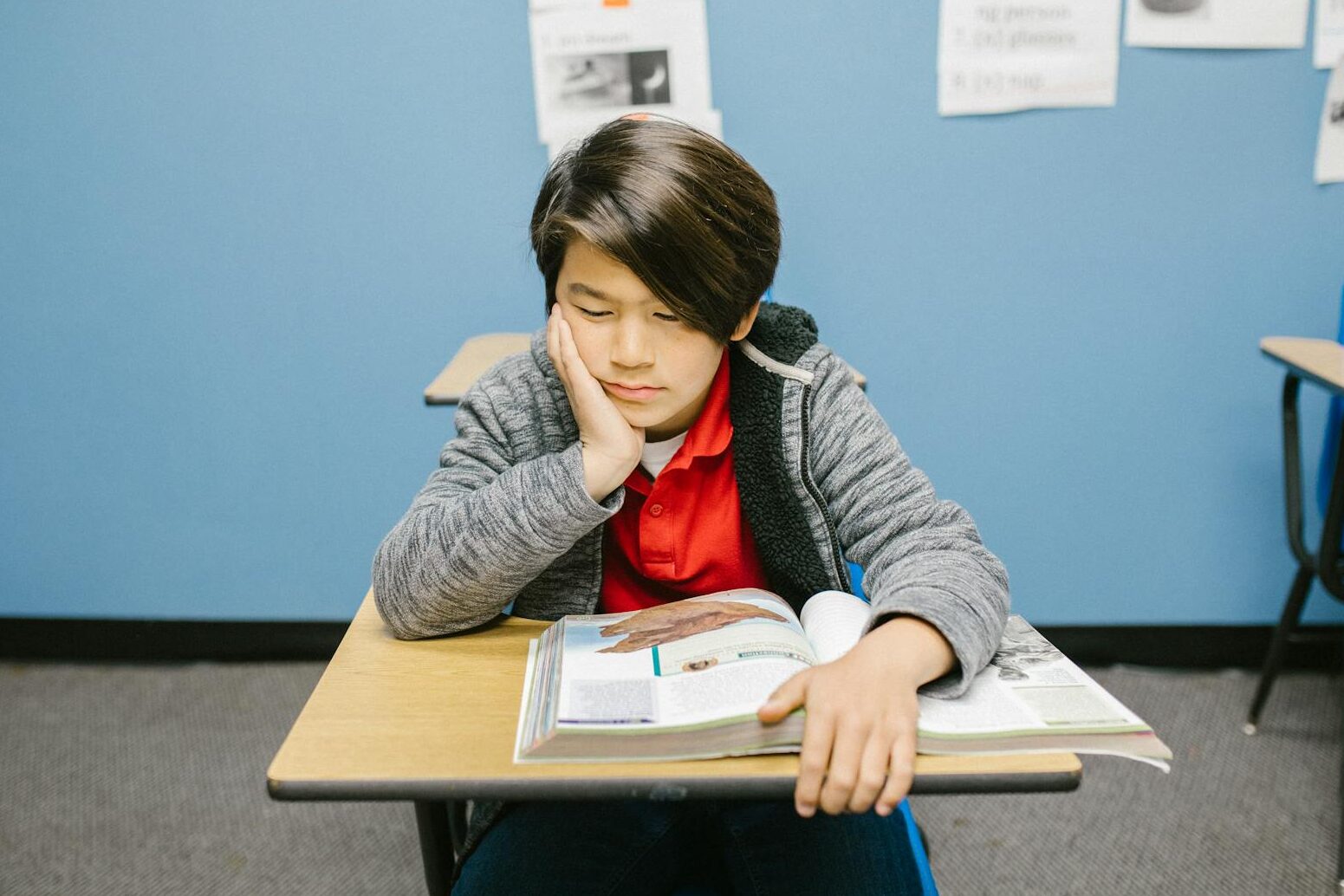 boy sitting on his desk looking lonely